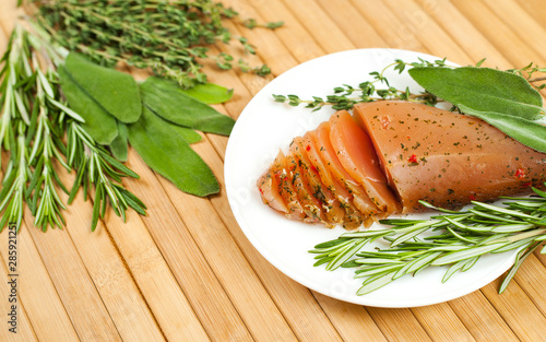 Sirloin meat with fresh rosemary, sage and thyme on a wooden table.  View from above. photo