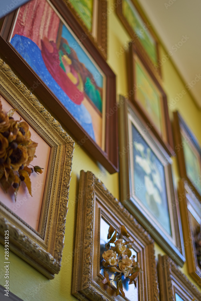 Group of framed paintings hanging on a wall