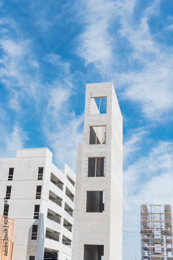 Elevator tower and multi story parking garage of new urban apartment building under construction Elevator tower and multi story parking garage of new urban apartment building under construction