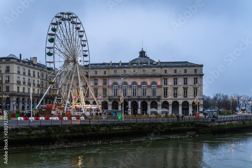 Bayonne city hall and Ferris wheel on the banks of Nive river, France.