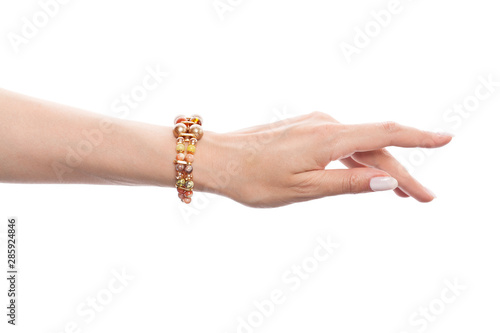 Hand in jewelry bracelet with opal, amber, jasper, pearls and gold beads isolated on white background