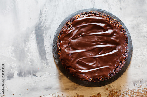 Chocolate brownie cake with ganashe topping on gray background