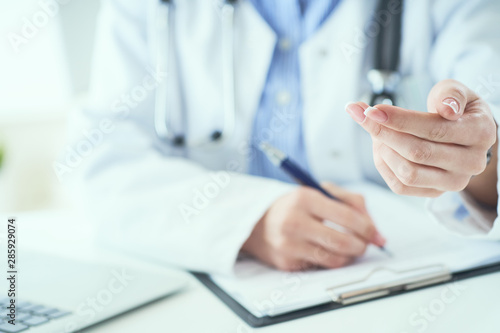 Fototapeta Naklejka Na Ścianę i Meble -  Female doctor explaining patient symptoms or asking a question as they discuss together in a consultation. Doctor held out his hand to the patient close-up.