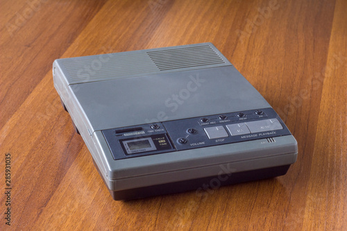 old vintage cassette answering machine on a wooden table surface