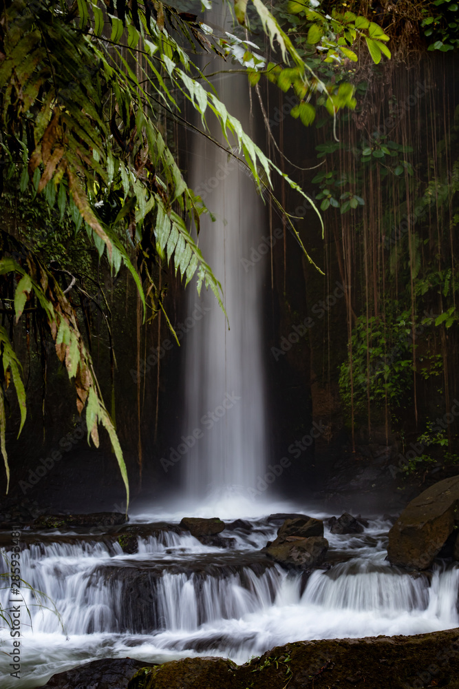 Waterfall landscape. Slow shutter speed, motion photography. Beautiful hidden Sumampan waterfall in tropical rainforest in Bali near Ubud.