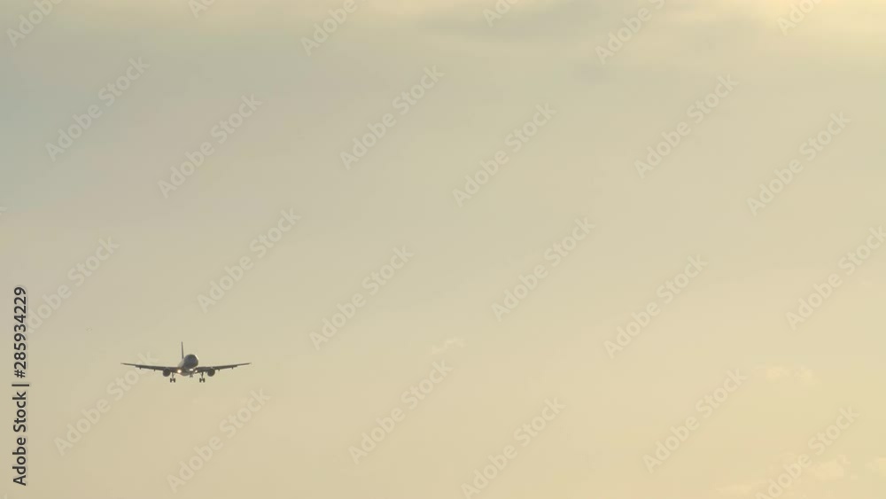 Small civil jet plane is landing in windy weather during beautiful yellow sunset with clear sky Small civil jet plane is landing in windy weather during beautiful yellow sunset with clear sky