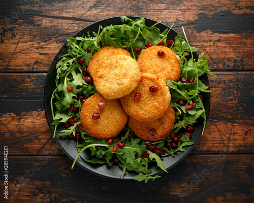 Thai food spicy fish cakes served with pomegranate seeds and wild rocket, arugula salad.