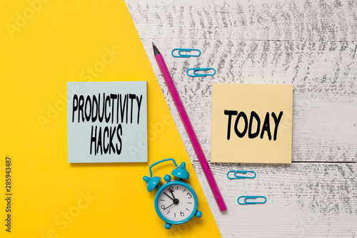 Word writing text Productivity Hacks. Business photo showcasing tricks that you get more done in the same amount of time Notepads marker pen colored paper sheet alarm clock wooden background