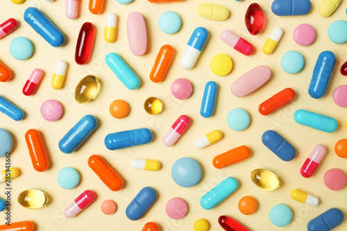 Many different pills on color background, top view