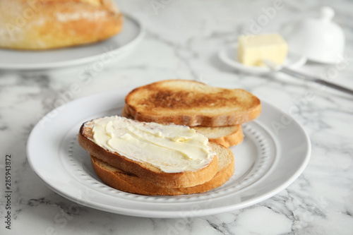 Tasty bread with butter served for breakfast on marble table