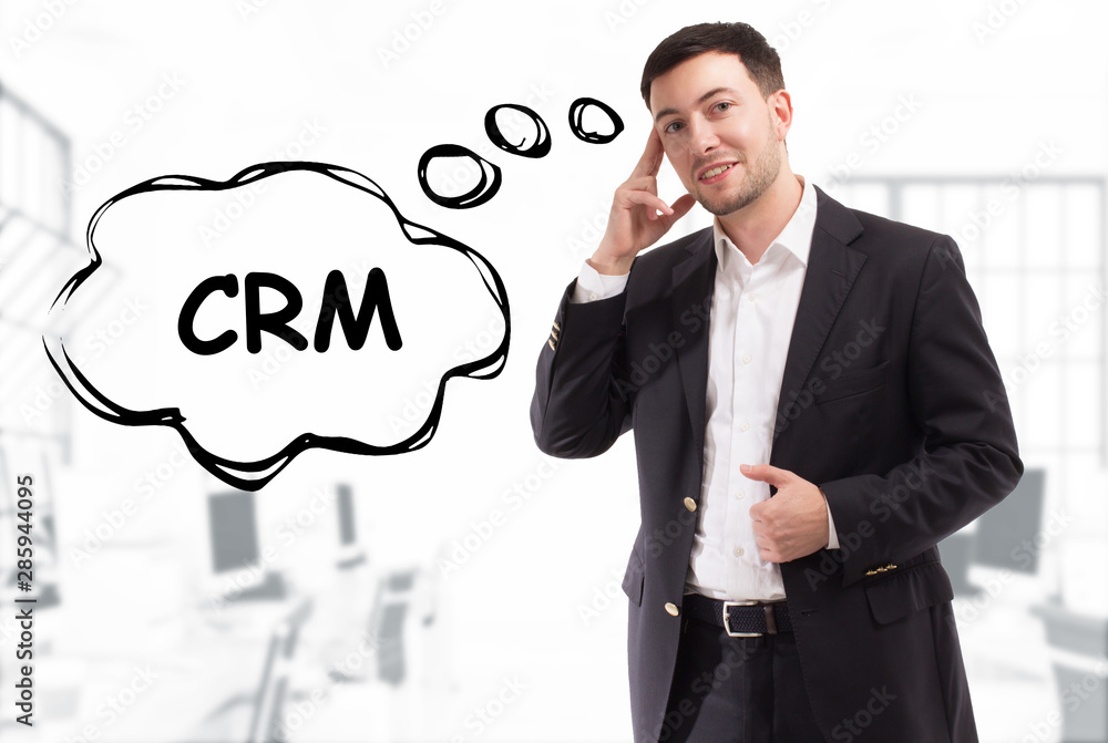 Business, technology, internet and network concept. The young businessman comes up with the keyword: CRM Business, technology, internet and network concept. The young businessman comes up with the keyword: CRM