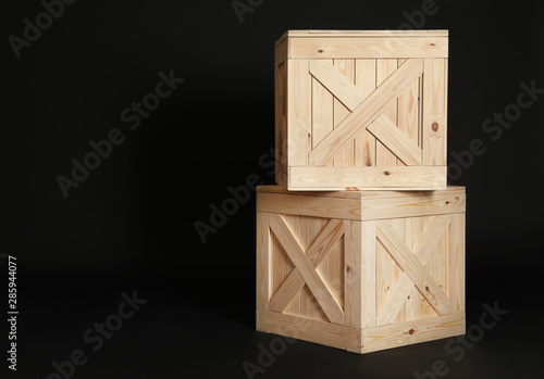 Wooden crates on black background. Space for text