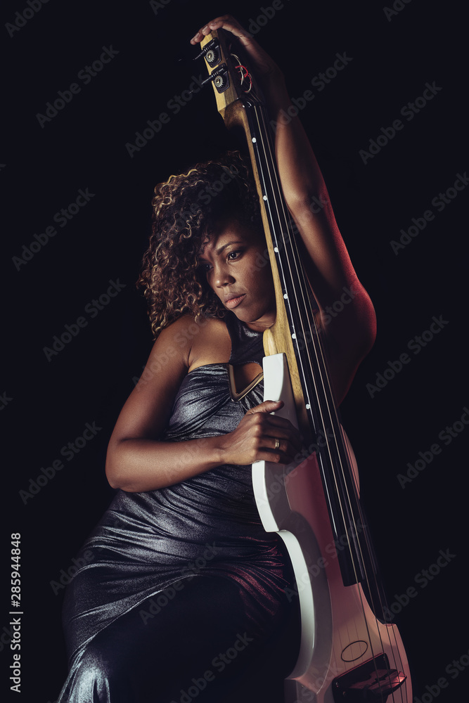 Sensual musician. African girl playing double bass.