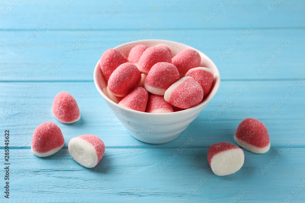 Bowl of tasty jelly candies on blue wooden table Bowl of tasty jelly candies on blue wooden table
