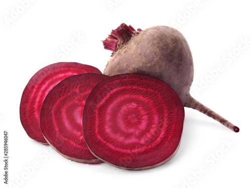 Whole and cut fresh red beets on white background
