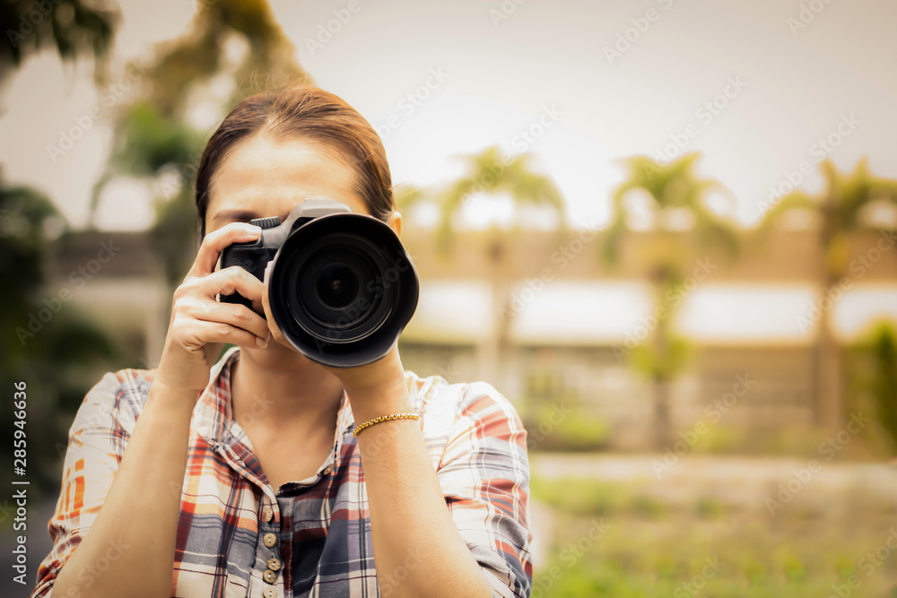 Woman photographer is taking images with dslr camera.Asian woman photographer