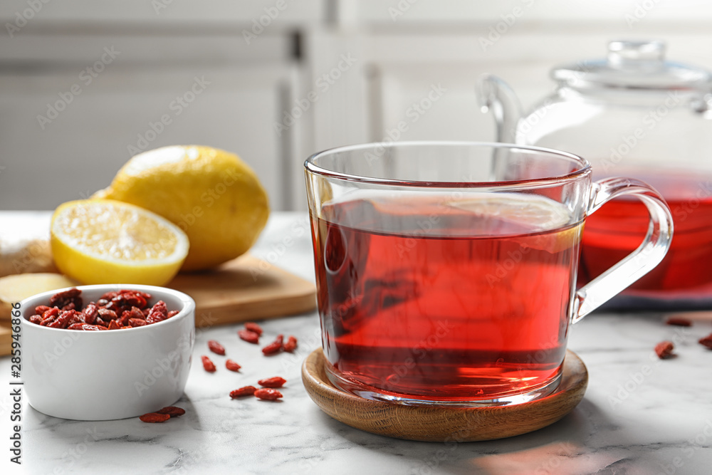 Healthy goji tea with lemon in glass cup on marble table Healthy goji tea with lemon in glass cup on marble table