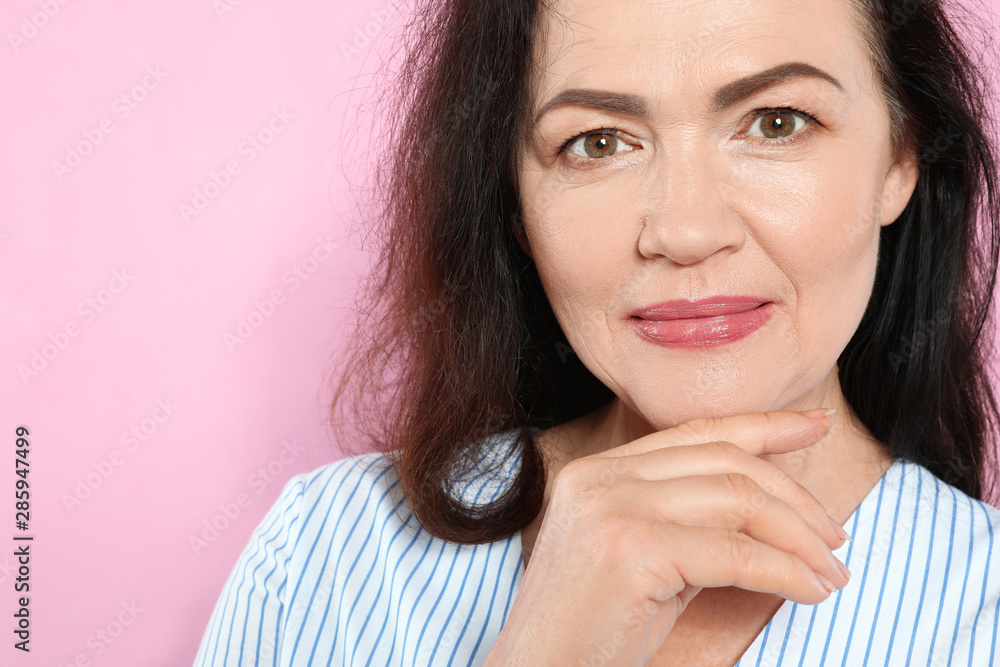 Portrait of mature woman with beautiful face on pink background Portrait of mature woman with beautiful face on pink background