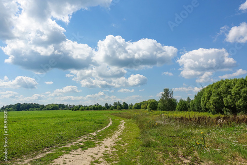 Country road and green grass and cloud sky. Russia