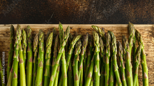 Freshly picked organic asparagus tips on wooden board