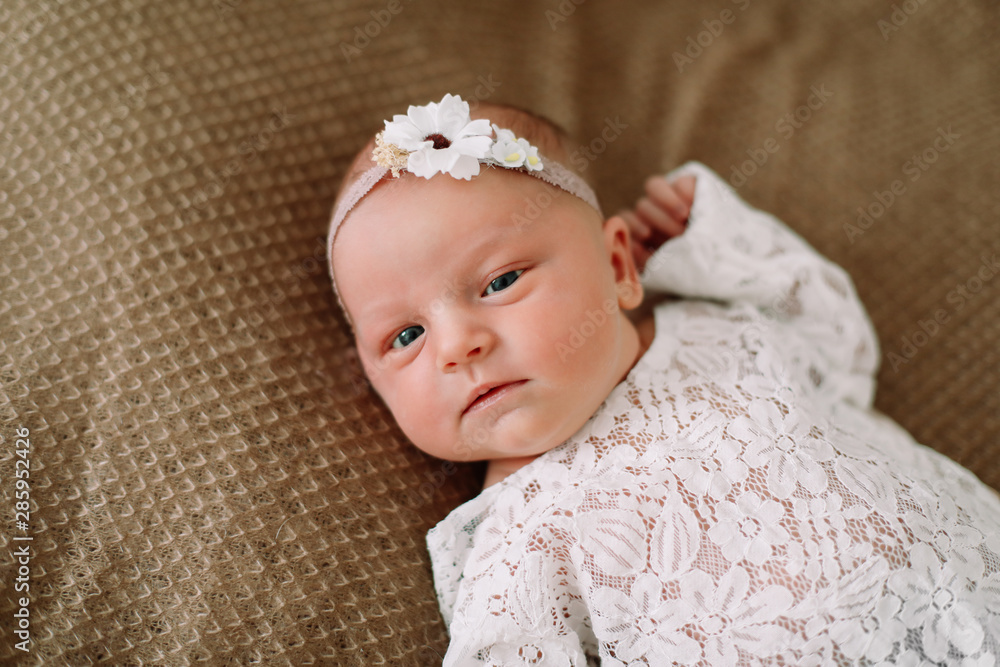 Close-up lovely newborn baby girl on a blanket. A portrait of a beautiful newborn baby girl wearing a headband. Closeup photo Close-up lovely newborn baby girl on a blanket. A portrait of a beautiful newborn baby girl wearing a headband. Closeup photo