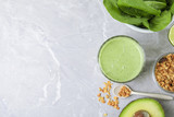 Flat lay composition with tasty avocado smoothie on grey marble table. Space for text