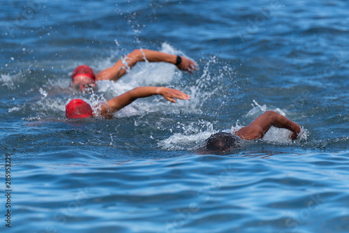 Group people in wetsuit swimming at triathlon