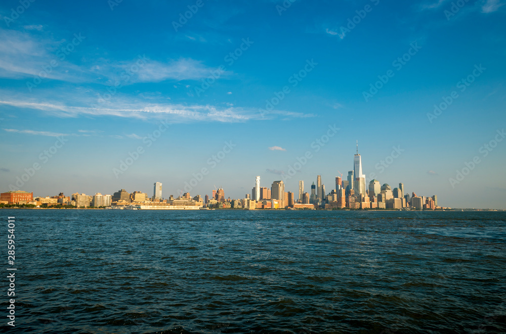 Golden sunset view of the Downtown Manhattan New York City skyline from across the Hudson River in New Jersey