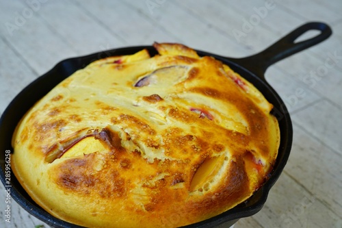 A peach Baby Dutch pancake clafoutis in a cast iron pan photo