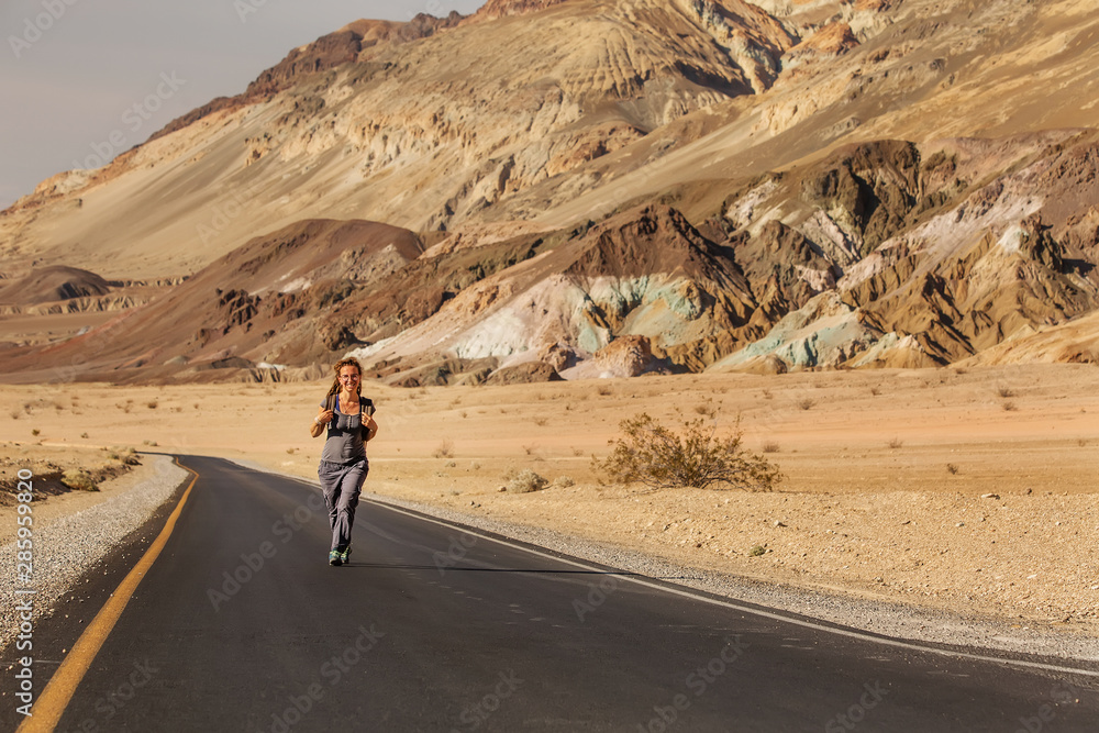 hitchhiker woman walking on a road in USA hitchhiker woman walking on a road in USA
