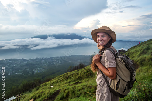 Woman enjoying sunrise from a top of mountain Batur, Bali, Indonesia.