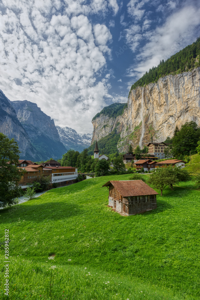 Famous view of Lauterbrunnen town in Swiss Alps valley with gorgeous Staubbach waterfalls in the background, Switzerland