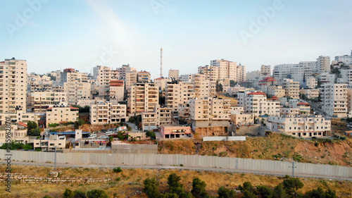 Palestinian Town Behind concrete Wall Aerial view Flying over Palestinian Town Shuafat Close to Jerusalem Drone footage  photo