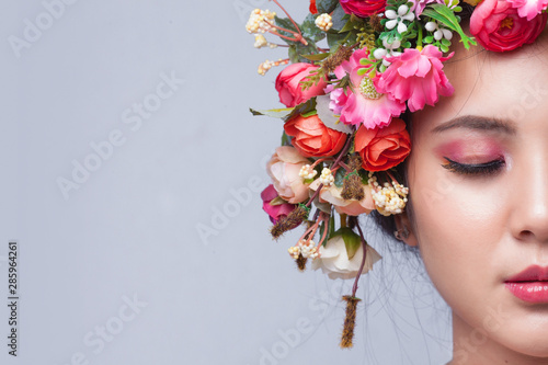 Close up of beautiful young asian woman with flowers. Brunette woman with lux...
