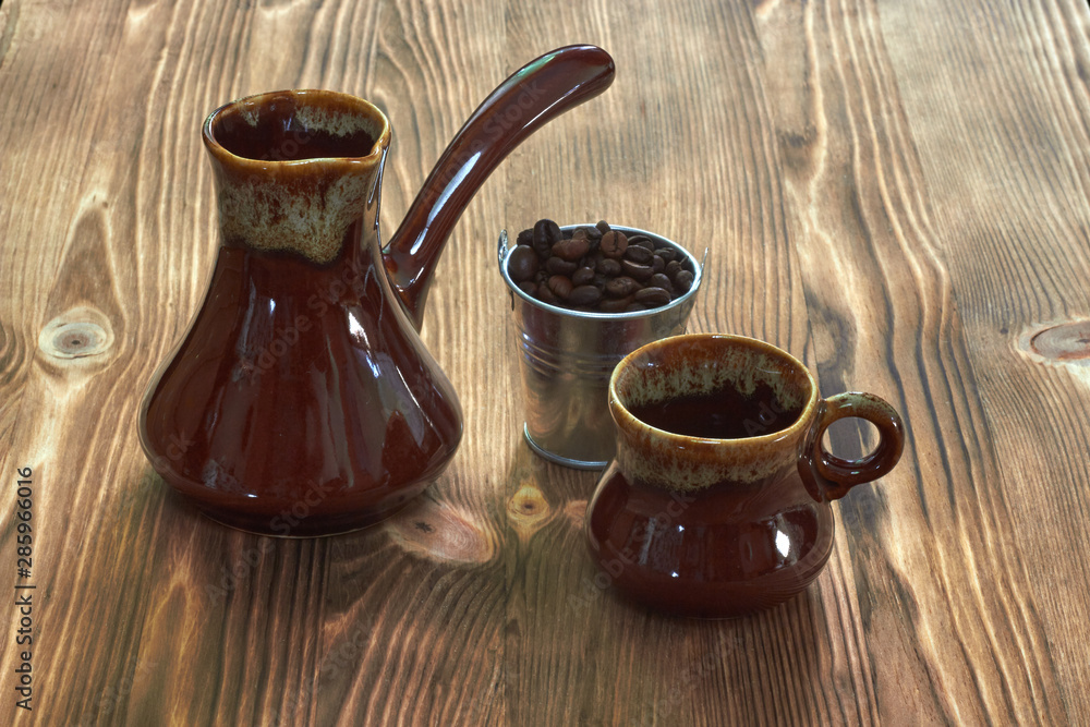cup with cezve on a wooden table cup with cezve on a wooden table
