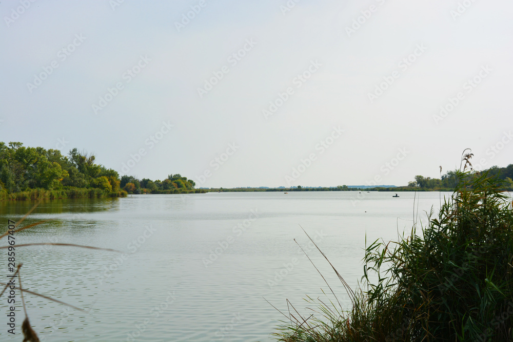 Beautiful view of the Samara River with picturesque steep banks and coast, trees, greenery and rich sky. Bright and unforgettable nature in the housing estate, Shevchenko, Dnipro, Ukraine.