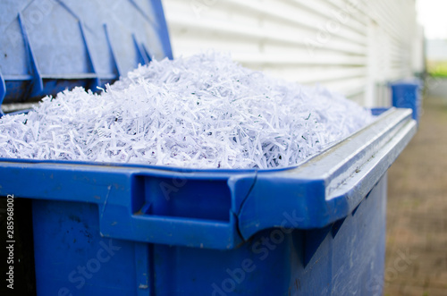 Blue whelie bin full of shredded paper