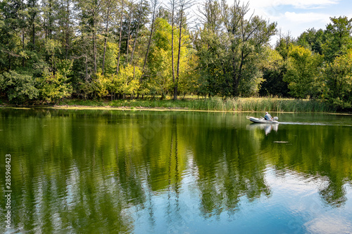 On a river on a sunny summer day against a background of green trees