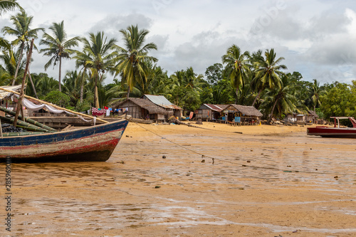 Beach with old boats at ebb, palm trees in background at Lokobe nature strict reserve in Madagascar, Nosy Be, Africa