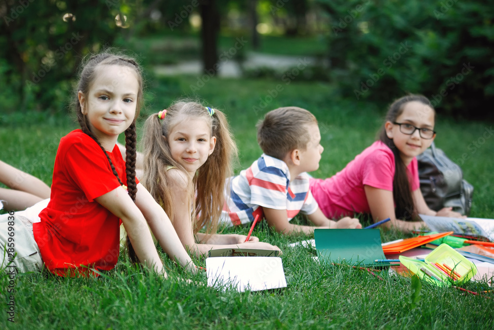 Fototapeta premium Children lying on the green grass.