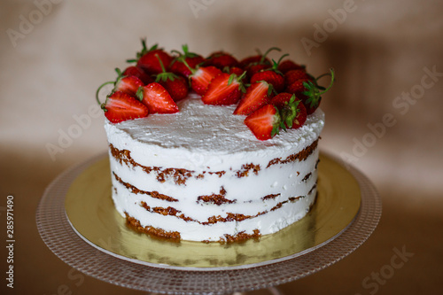 the beautiful cake with strawberries and cream on table