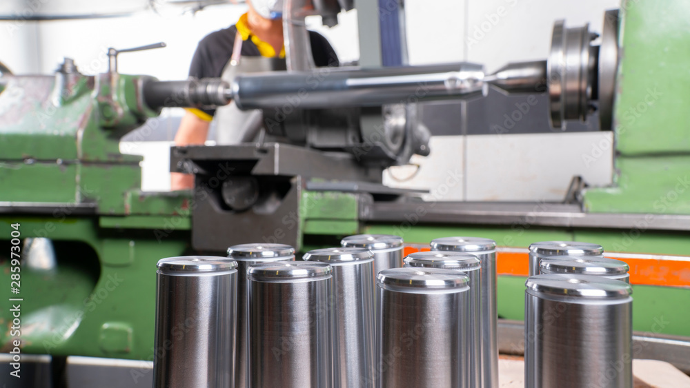 factory employee engaged in the production of pin bushing on the lathe in the factory factory employee engaged in the production of pin bushing on the lathe in the factory