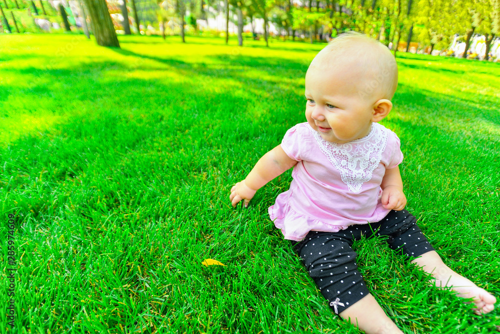 Little girl sitting on green grass, close up. Little girl sitting on green grass, close up.