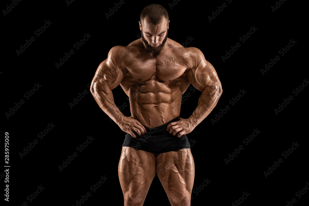 Muscular man showing muscles isolated on the black background. Strong male  naked torso abs Stock Photo