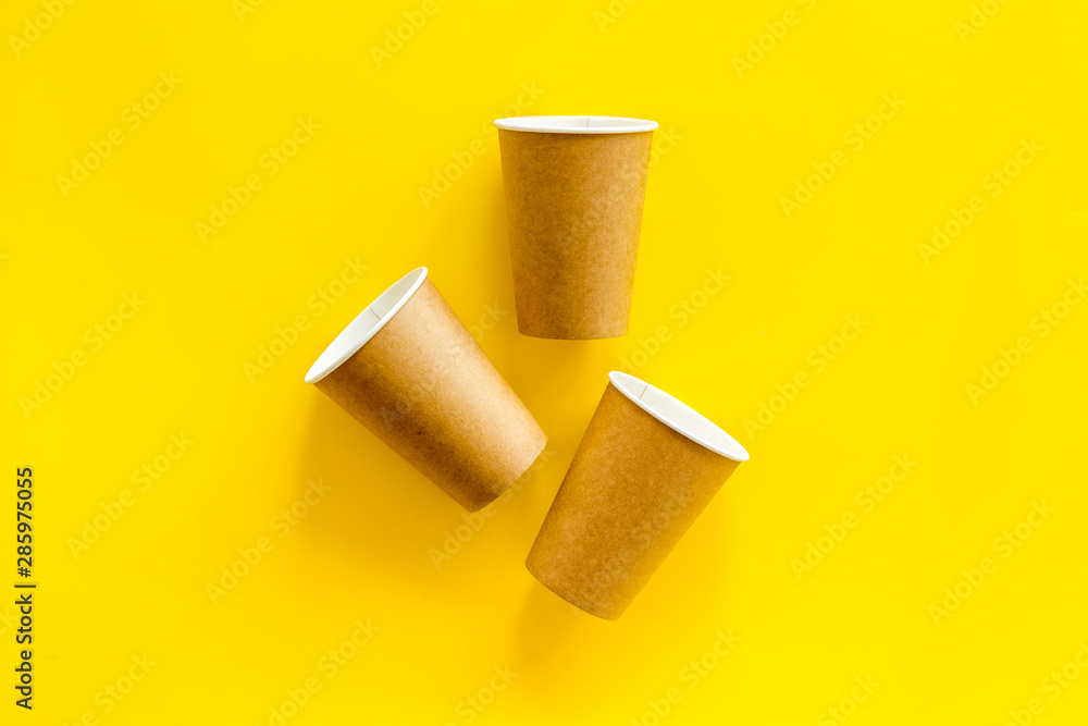 Paper cups for coffee to go on yellow background top view Paper cups for coffee to go on yellow background top view