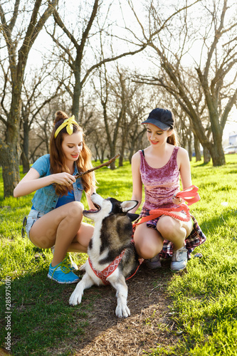 Twin sister in the park with a dog