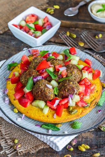 Curried chickpea cake with pistachio lamb meatballs and tomato sambal