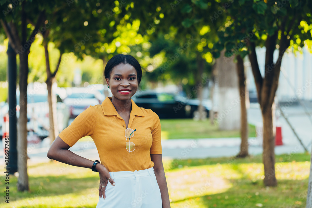 Young cool black skin girl with glasses walking in the street. Young cool black skin girl with glasses walking in the street.