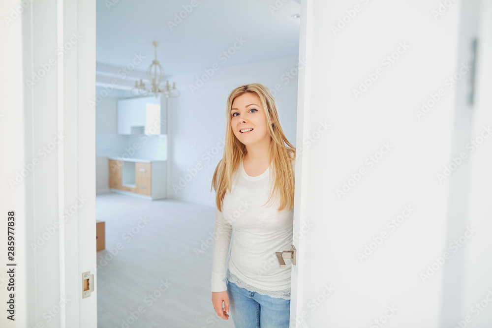 Cheerful young woman inviting people to enter in home. Cheerful young woman inviting people to enter in home.