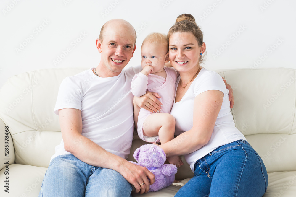 Family and children concept - Smiling mother and father holding their newborn baby daughter at home Family and children concept - Smiling mother and father holding their newborn baby daughter at home